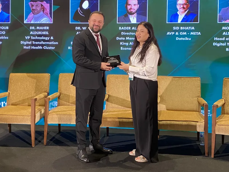 Dr. Mohammad Alsaadany receiving a plaque on stage at the Middle East Enterprise AI and Analytics Summit 2024